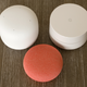 The Nest Wifi Point (upper left) compared to the original Google Wifi access point (upper right) and the new Nest Mini smart speaker (bottom).